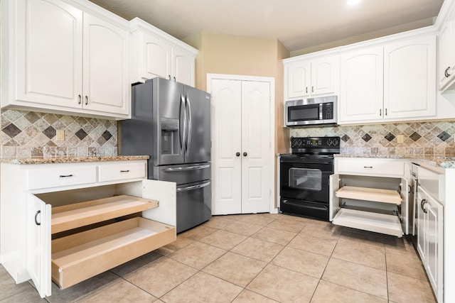 13727 Fountainview Dr, Montgomery, TX 77356 - kitchen featuring appliances with stainless steel finishes, white cabinetry, tasteful backsplash, light stone countertops, and light tile patterned floors