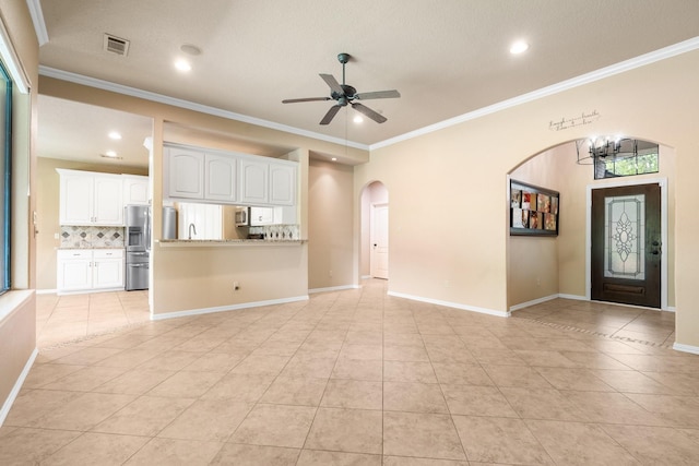 13727 Fountainview Dr, Montgomery, TX 77356 - unfurnished living room with arched walkways, light tile patterned floors, ceiling fan, recessed lighting, and crown molding