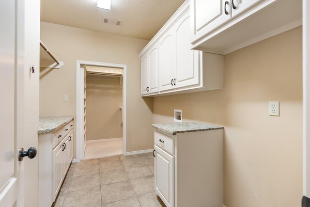 13727 Fountainview Dr, Montgomery, TX 77356 - washroom featuring cabinet space, hookup for a washing machine, and light tile patterned floors