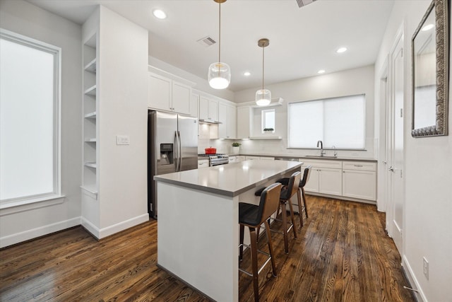 1050 Timbergrove Yards Ln, Houston, TX 77008 - kitchen featuring stainless steel appliances, white cabinets, dark wood finished floors, a kitchen island, and recessed lighting