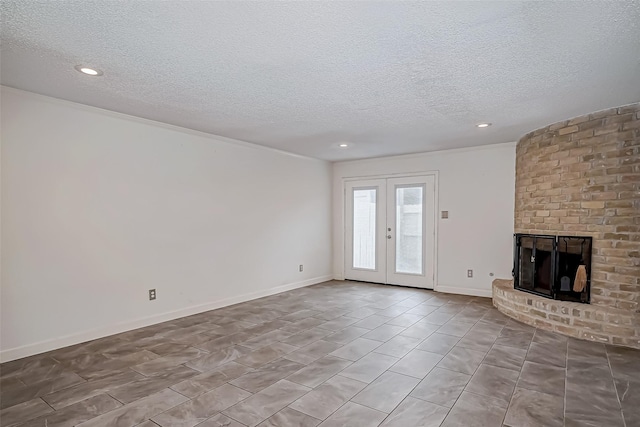 8427 Ariel St, Houston, TX 77074 - unfurnished living room featuring a textured ceiling, french doors, recessed lighting, a fireplace, and tile patterned flooring