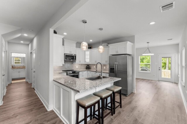 719 Cherokee Dr, Conroe, TX 77316 - kitchen featuring stainless steel appliances, light stone countertops, plenty of natural light, decorative backsplash, and recessed lighting