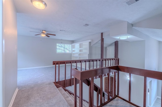 6507 Desert Rose Ln, Houston, TX 77086 - hallway with an upstairs landing, carpet floors, and a textured ceiling