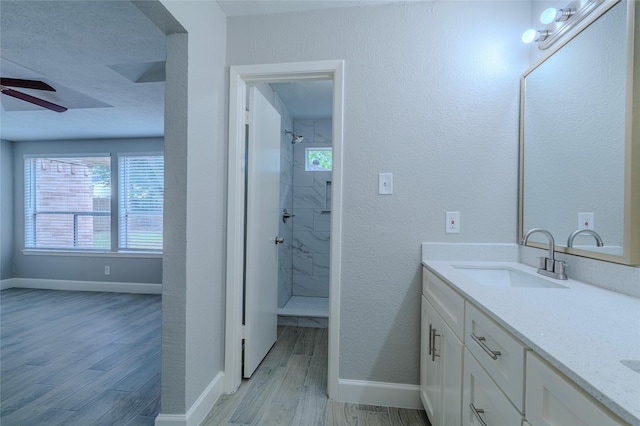 6507 Desert Rose Ln, Houston, TX 77086 - full bath featuring double vanity, wood finished floors, tiled shower, and a ceiling fan