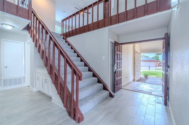 6507 Desert Rose Ln, Houston, TX 77086 - entrance foyer featuring light wood-style flooring, stairway, a textured wall, and a high ceiling