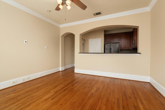 1774 Aden Dr, Houston, TX 77003 - empty room featuring a ceiling fan, ornamental molding, wood finished floors, and arched walkways
