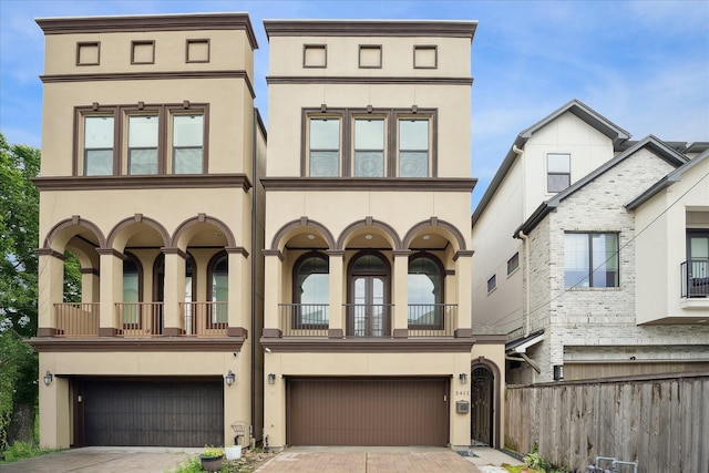 5411 Gibson St, Houston, TX 77007 - townhome / multi-family property with stucco siding, an attached garage, a balcony, and decorative driveway