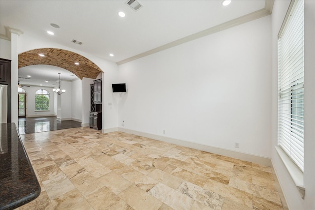 5411 Gibson St, Houston, TX 77007 - spare room with arched walkways, stone tile flooring, a chandelier, recessed lighting, and ornamental molding
