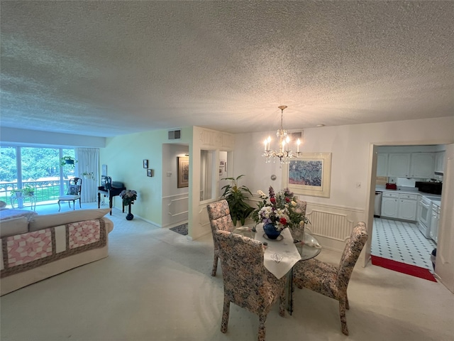 5050 Ambassador Way Unit 201, Houston, TX 77056 - dining area featuring light colored carpet, a chandelier, and a textured ceiling