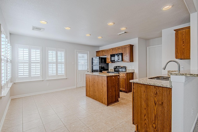 9614 Summer Laurel Ln, Houston, TX 77088 - kitchen featuring black appliances, brown cabinets, recessed lighting, a kitchen island, and light stone countertops
