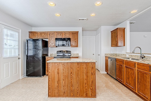 9614 Summer Laurel Ln, Houston, TX 77088 - kitchen featuring black appliances, a center island, light tile patterned floors, light stone counters, and brown cabinetry