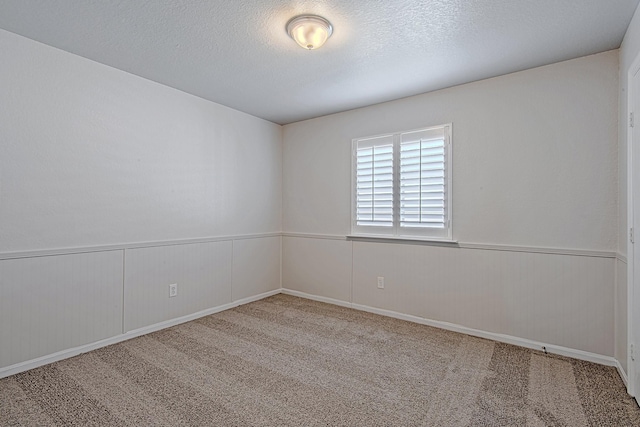 9614 Summer Laurel Ln, Houston, TX 77088 - unfurnished room with carpet flooring, a wainscoted wall, and a textured ceiling
