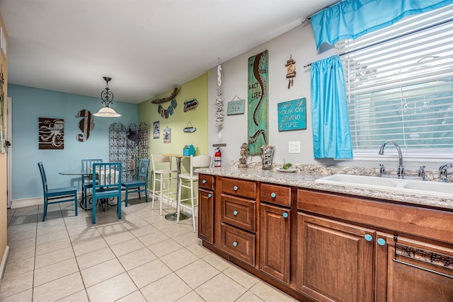 1315 40th St, Rear, Galveston, TX 77550 - kitchen with light tile patterned flooring, light countertops, brown cabinetry, and pendant lighting