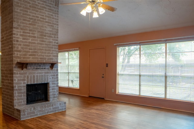 4822 Misty Shadows Dr, Houston, TX 77041 - unfurnished living room with a brick fireplace, wood finished floors, ceiling fan, and vaulted ceiling