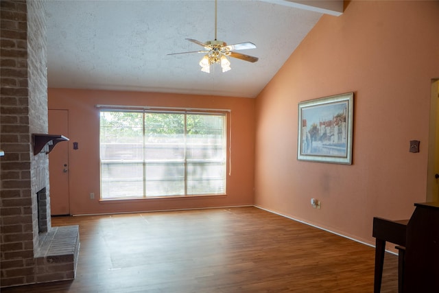 4822 Misty Shadows Dr, Houston, TX 77041 - unfurnished living room featuring vaulted ceiling, a ceiling fan, wood finished floors, a brick fireplace, and a textured ceiling