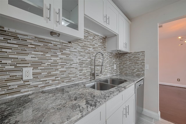 3930 Daphne St, Houston, TX 77021 - kitchen featuring backsplash, light stone countertops, stainless steel dishwasher, and white cabinets