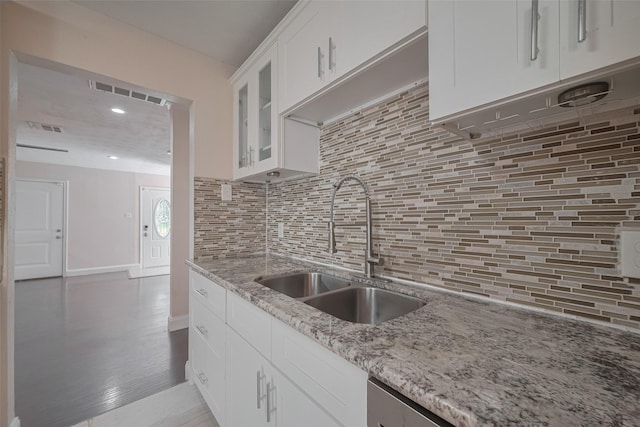 3930 Daphne St, Houston, TX 77021 - kitchen with glass insert cabinets, light stone counters, white cabinets, decorative backsplash, and recessed lighting