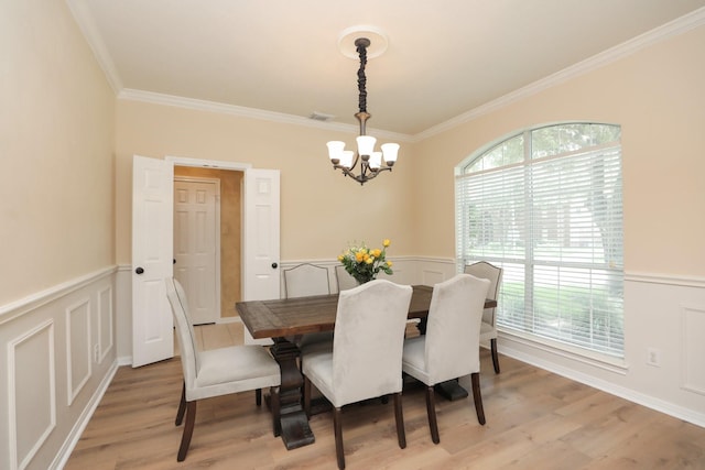 15802 Aberdeen Trails Dr, Houston, TX 77095 - dining space with a chandelier, crown molding, light wood-style flooring, a wainscoted wall, and a decorative wall