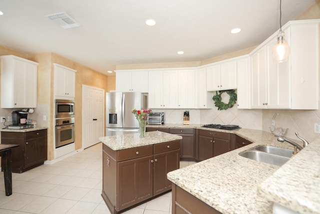 15802 Aberdeen Trails Dr, Houston, TX 77095 - kitchen with appliances with stainless steel finishes, dark brown cabinetry, a kitchen island, white cabinetry, and recessed lighting