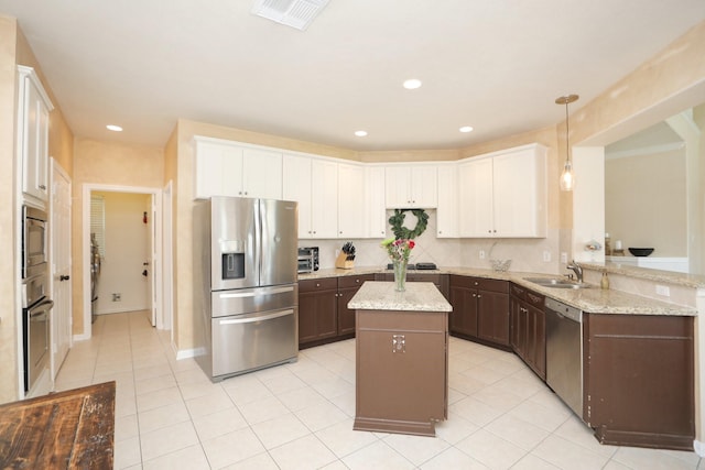 15802 Aberdeen Trails Dr, Houston, TX 77095 - kitchen with appliances with stainless steel finishes, light tile patterned flooring, a kitchen island, white cabinets, and light stone counters