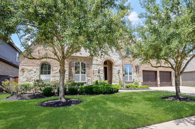 27522 Blackstone Canyon Ln, Katy, TX 77494 - view of front of home with stone siding, a front lawn, concrete driveway, an attached garage, and brick siding