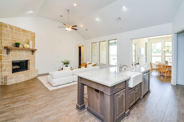 27522 Blackstone Canyon Ln, Katy, TX 77494 - kitchen featuring open floor plan, stainless steel dishwasher, light wood-style floors, ceiling fan, and an island with sink