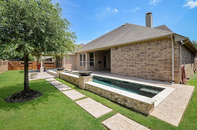 27522 Blackstone Canyon Ln, Katy, TX 77494 - rear view of property featuring a jacuzzi, brick siding, a patio, and a chimney