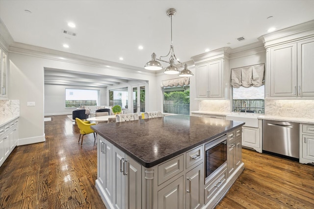 8304 Maple Ct, Bellaire, TX 77401 - kitchen featuring stainless steel appliances, ornamental molding, a kitchen island, open floor plan, and decorative backsplash