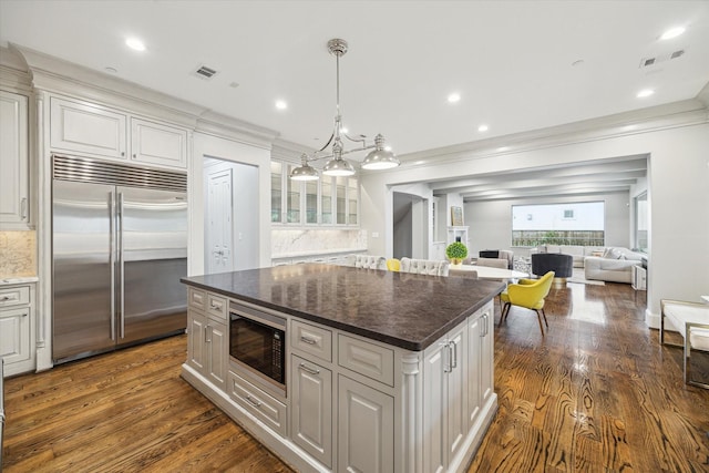 8304 Maple Ct, Bellaire, TX 77401 - kitchen featuring built in appliances, crown molding, a kitchen island, dark wood-style flooring, and white cabinetry