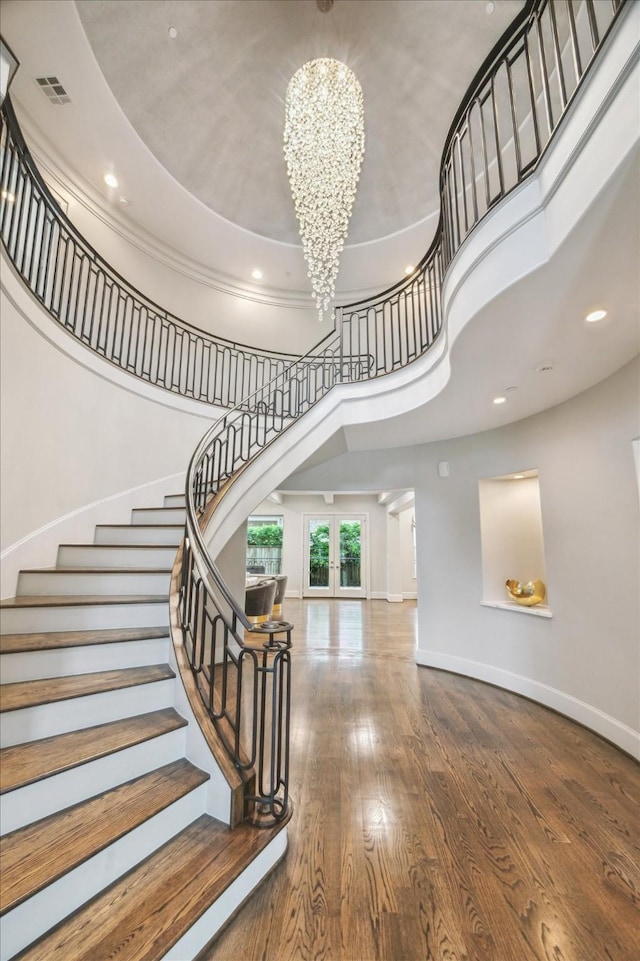 8304 Maple Ct, Bellaire, TX 77401 - staircase with a towering ceiling, a chandelier, wood finished floors, and recessed lighting