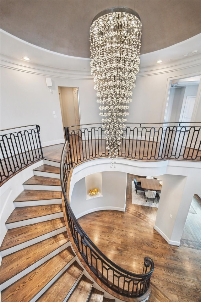 8304 Maple Ct, Bellaire, TX 77401 - staircase featuring wood finished floors, crown molding, recessed lighting, and a chandelier