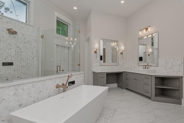 27003 Hidden Grove Landing Dr, Spring, TX 77386 - full bathroom featuring a shower with door, marble look tile flooring, a soaking tub, tile walls, and vanity