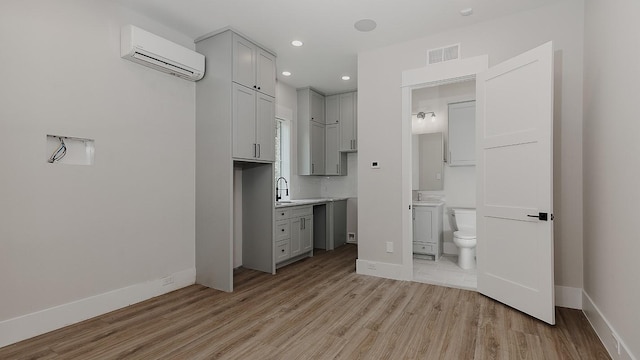 27003 Hidden Grove Landing Dr, Spring, TX 77386 - unfurnished bedroom featuring an AC wall unit, light wood-style floors, connected bathroom, and recessed lighting