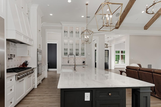 27003 Hidden Grove Landing Dr, Spring, TX 77386 - kitchen with a chandelier, stainless steel appliances, premium range hood, tasteful backsplash, and white cabinetry