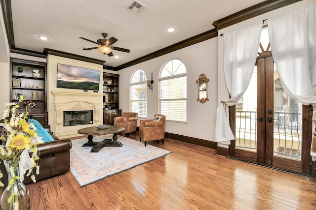 1241 W 24th St Unit B, Houston, TX 77008 - living area featuring ornamental molding, a ceiling fan, wood finished floors, a glass covered fireplace, and french doors