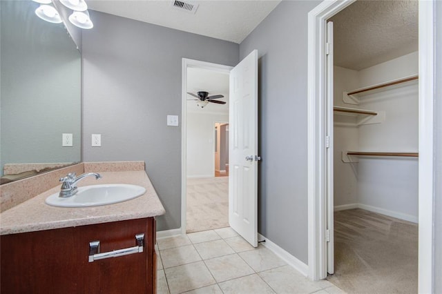 2666 Skyview Knoll Ct, Houston, TX 77047 - bathroom with vanity, a spacious closet, a ceiling fan, a textured ceiling, and tile patterned flooring