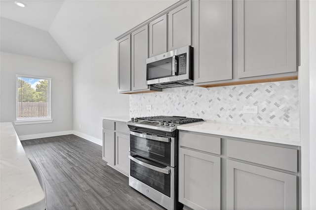 10329 S Goshawk Trl, Conroe, TX 77385 - kitchen with appliances with stainless steel finishes, gray cabinetry, light countertops, lofted ceiling, and tasteful backsplash