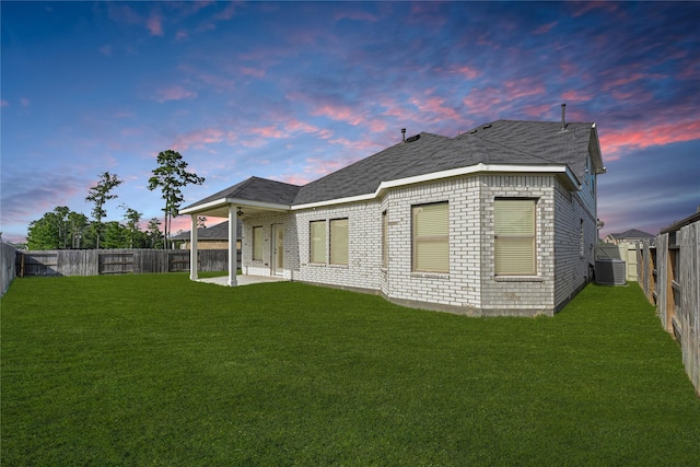 10329 S Goshawk Trl, Conroe, TX 77385 - back of property at dusk with a fenced backyard, brick siding, a patio, and roof with shingles