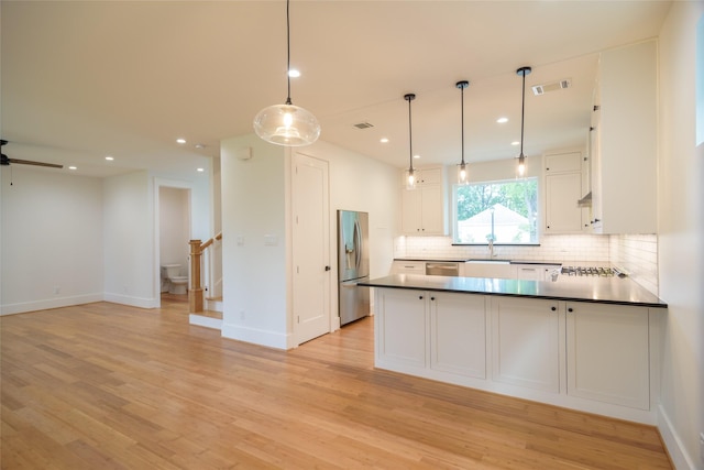 1037 Rutland St, Houston, TX 77008 - kitchen with appliances with stainless steel finishes, decorative backsplash, open floor plan, white cabinetry, and light wood finished floors