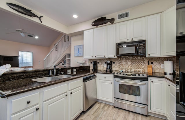 16713 Kingston Way, Jamaica Beach, TX 77554 - kitchen with appliances with stainless steel finishes, a peninsula, white cabinetry, dark stone counters, and decorative backsplash