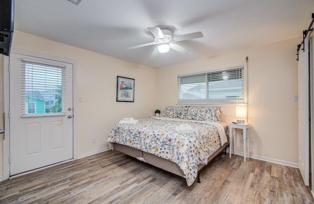 16713 Kingston Way, Jamaica Beach, TX 77554 - bedroom featuring a barn door, light wood-style floors, and a ceiling fan