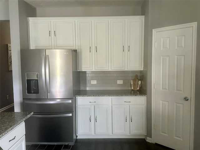 15619 Hanover Breeze Ln, Houston, TX 77044 - kitchen with stainless steel fridge with ice dispenser, white cabinets, light stone countertops, and decorative backsplash