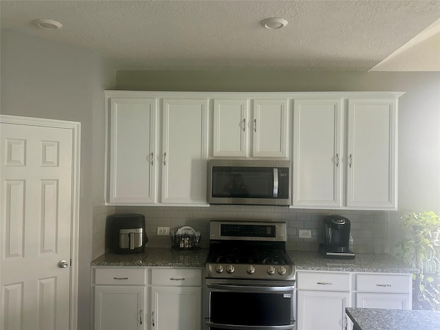 15619 Hanover Breeze Ln, Houston, TX 77044 - kitchen with stainless steel appliances, white cabinetry, decorative backsplash, a textured ceiling, and light stone countertops