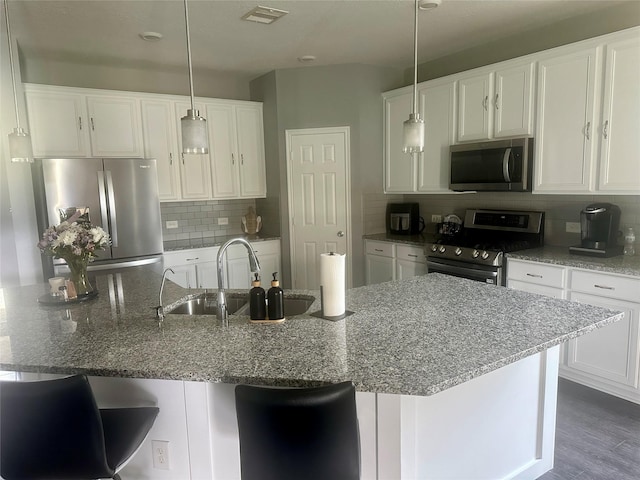 15619 Hanover Breeze Ln, Houston, TX 77044 - kitchen with stainless steel appliances, backsplash, and white cabinetry