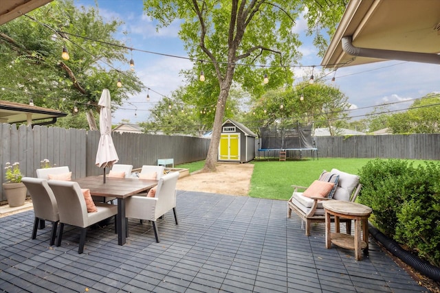 6210 Darnell St, Houston, TX 77074 - fenced backyard featuring a trampoline, a shed, outdoor dining space, and a deck