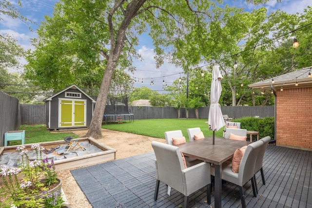 6210 Darnell St, Houston, TX 77074 - fenced backyard featuring outdoor dining area, a storage unit, a trampoline, and a deck