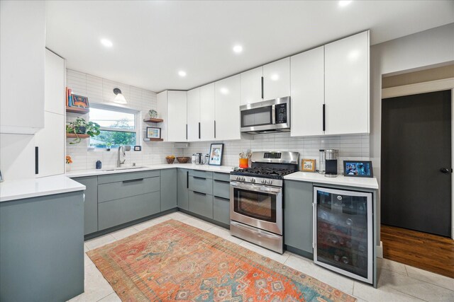 6210 Darnell St, Houston, TX 77074 - kitchen with appliances with stainless steel finishes, beverage cooler, gray cabinetry, decorative backsplash, and light tile patterned floors