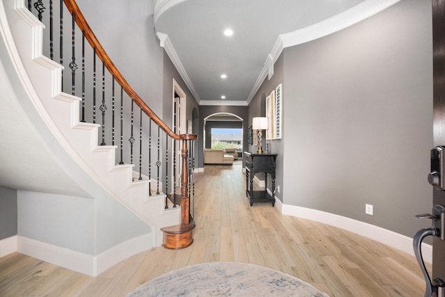 3038 S Island Dr, Seabrook, TX 77586 - entrance foyer featuring arched walkways, crown molding, light wood-style flooring, stairway, and recessed lighting