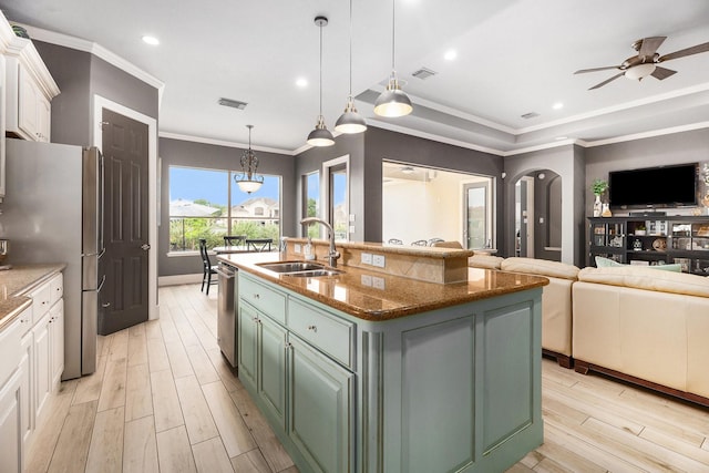 3038 S Island Dr, Seabrook, TX 77586 - kitchen with stainless steel appliances, light wood-style floors, open floor plan, arched walkways, and white cabinets