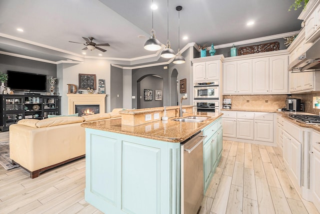 3038 S Island Dr, Seabrook, TX 77586 - kitchen with stainless steel appliances, ceiling fan, light wood-type flooring, white cabinetry, and crown molding
